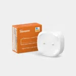Capteur de fuite d'eau Zigbee Sonoff blanc avec ses deux électrodes, posé devant son emballage orange